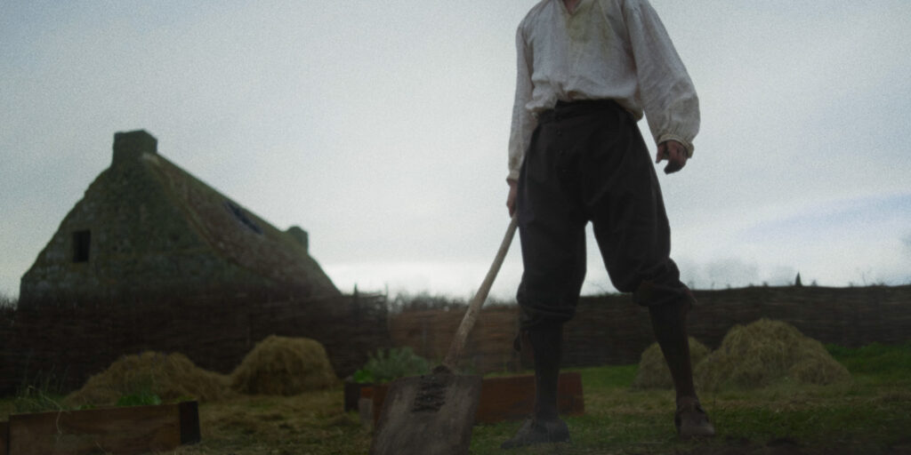 A man stood in a field, head out of picture
