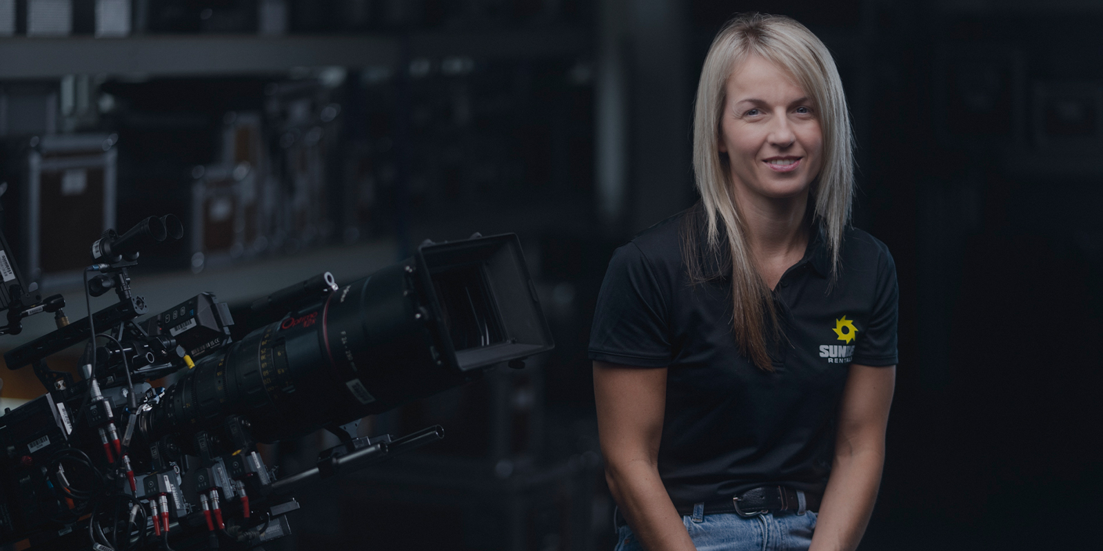 A woman sat smiling in a Sunbelt Rentals uniform